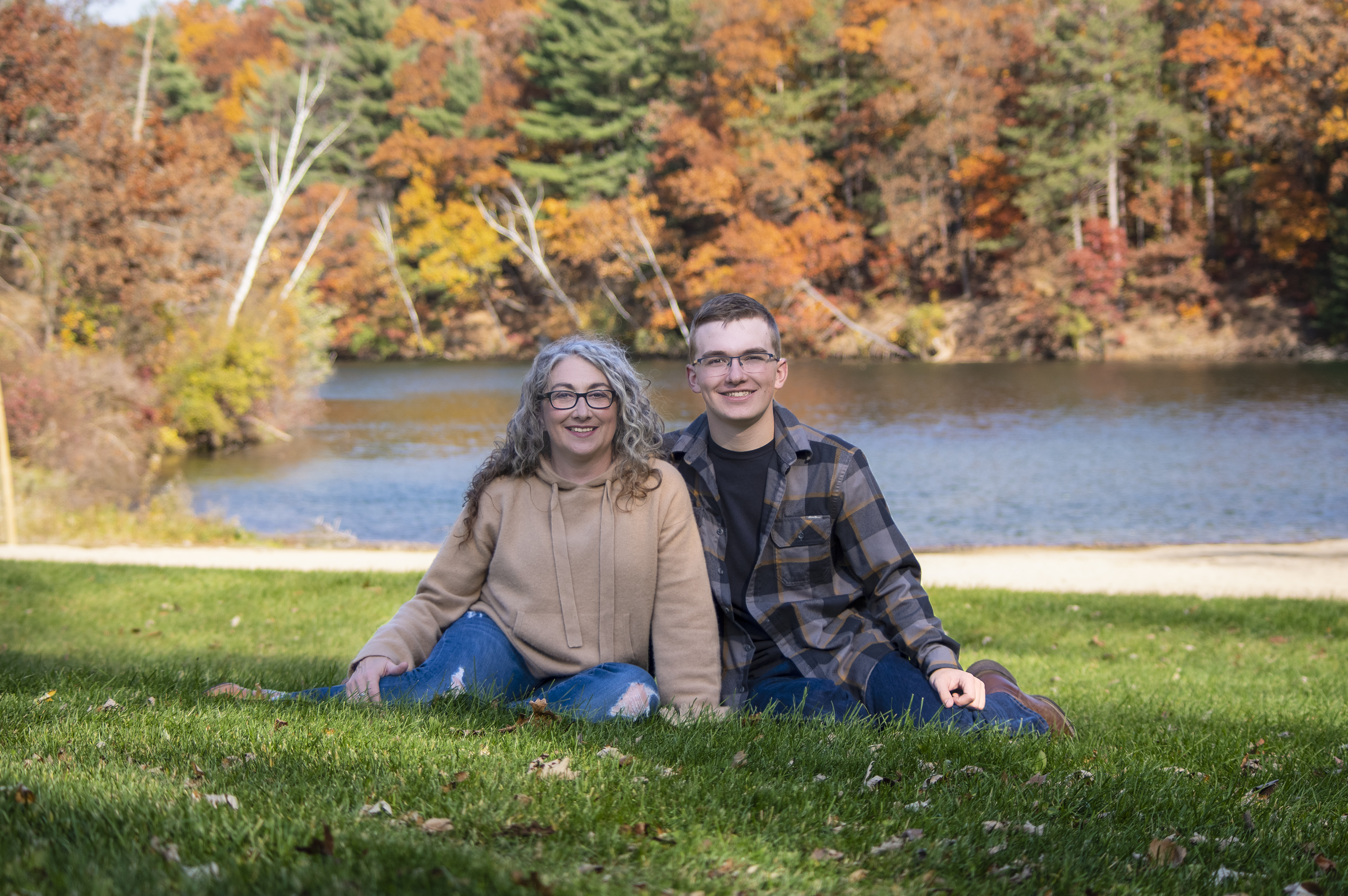 April with family sitting outdoors by the water in autumn