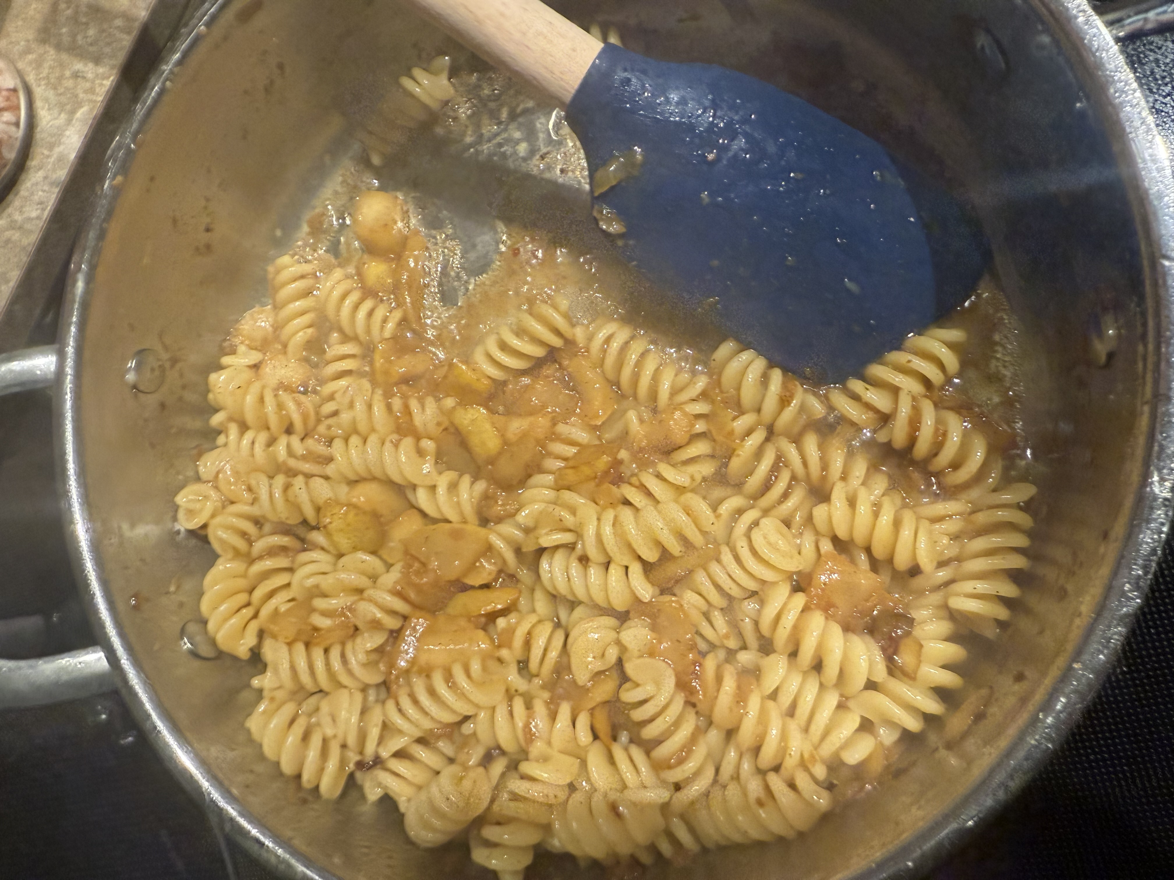 Adding the pasta to the skillet.